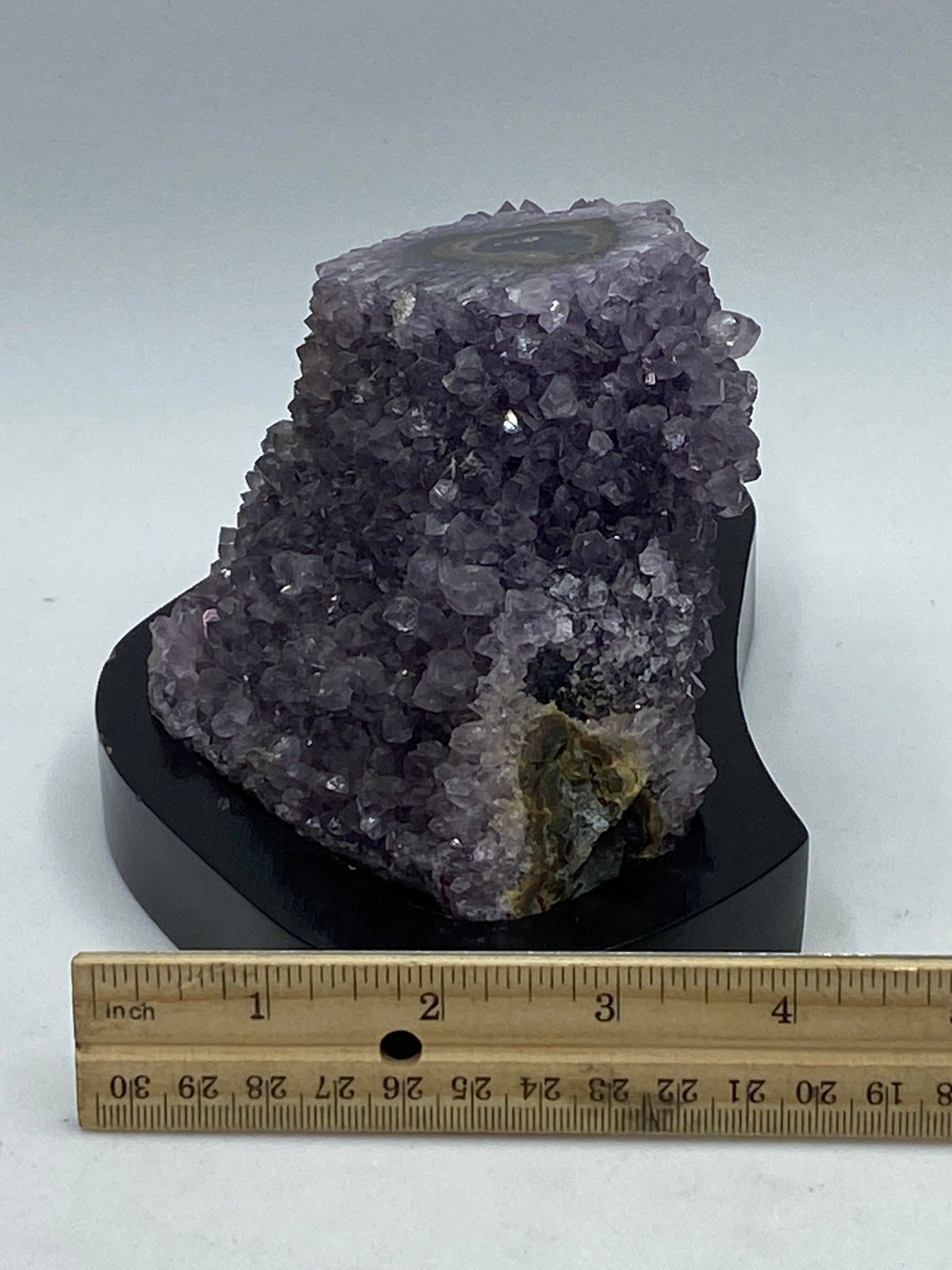 Amethyst geode stalagmite on a wood base