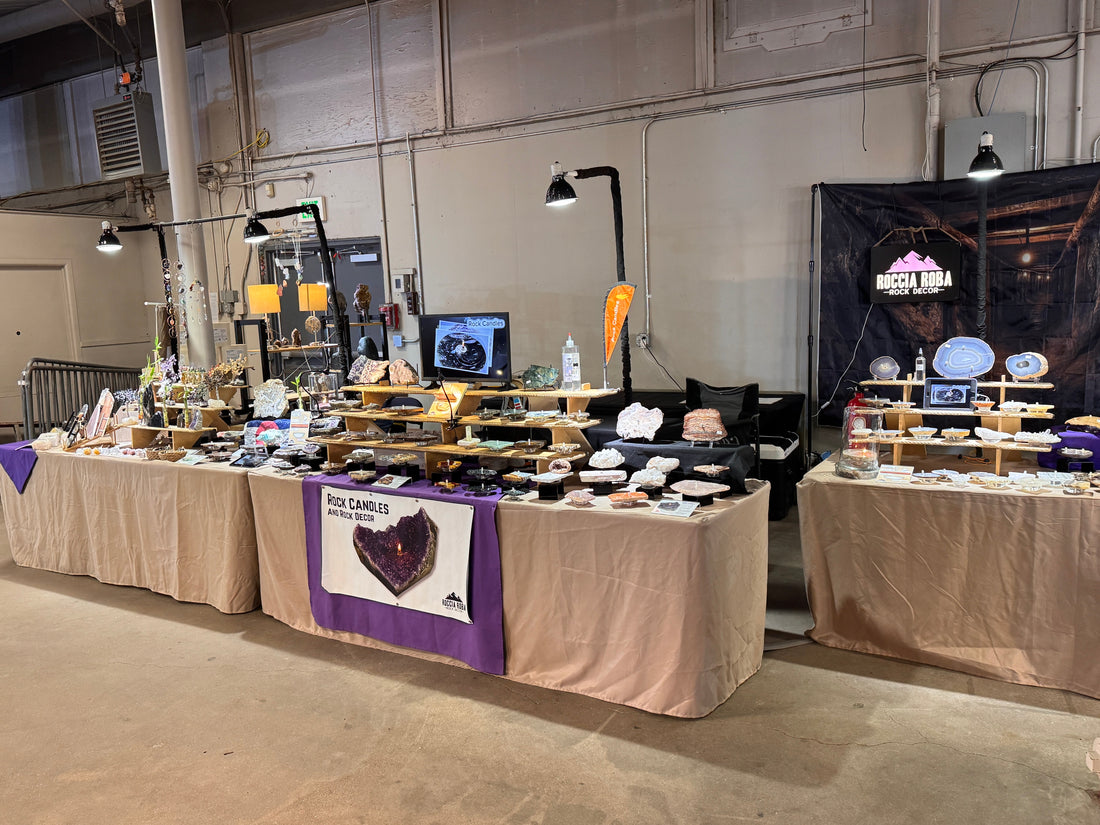 Roccia Roba booth at the Denver Gem & Mineral Show featuring rock candles, crystals, geodes, and mineral specimens on display