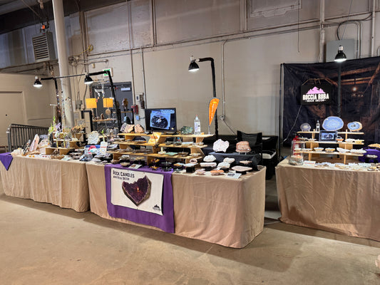 Roccia Roba booth at the Denver Gem & Mineral Show featuring rock candles, crystals, geodes, and mineral specimens on display