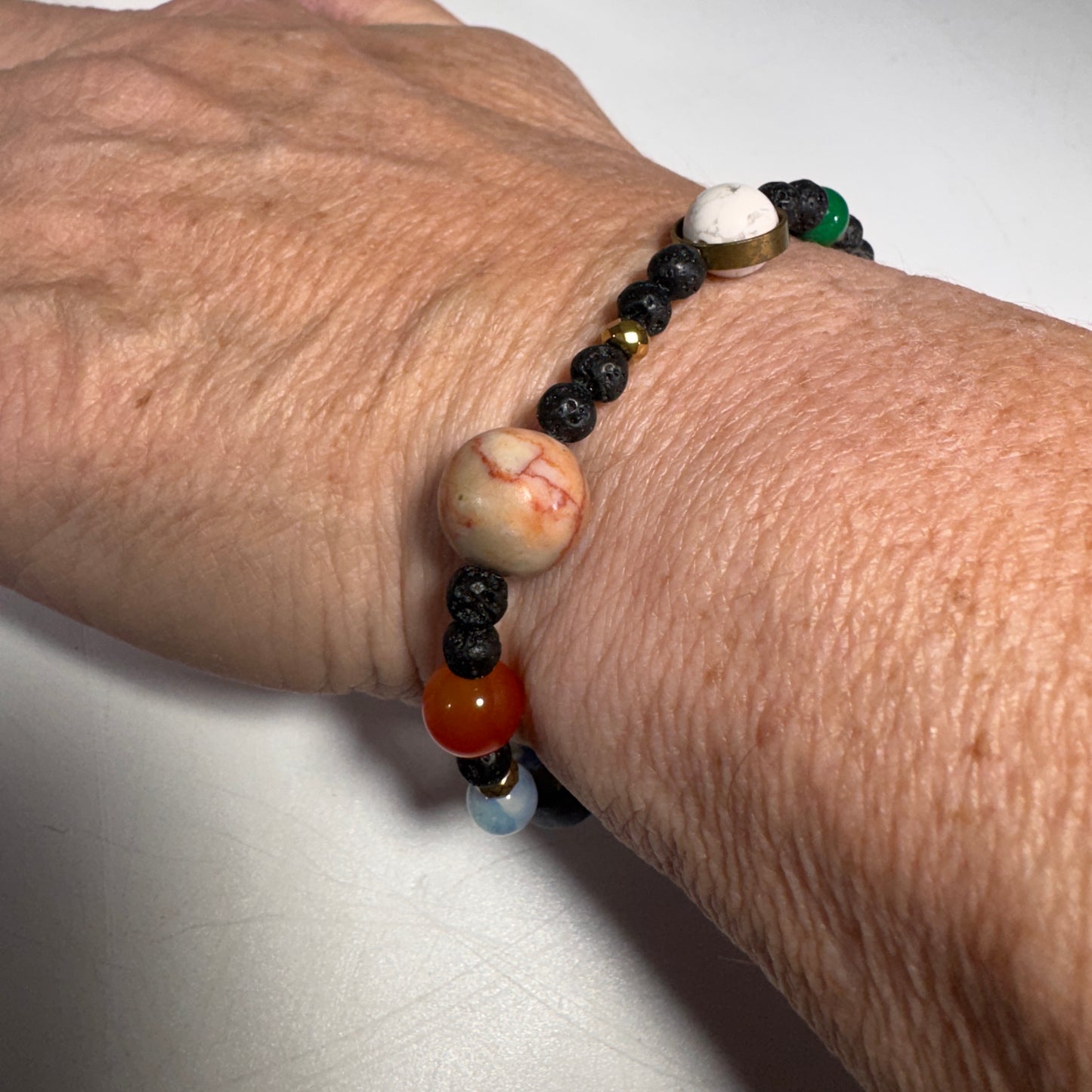 Close-up of a wrist wearing a beaded You are the Sun stretchy bracelet