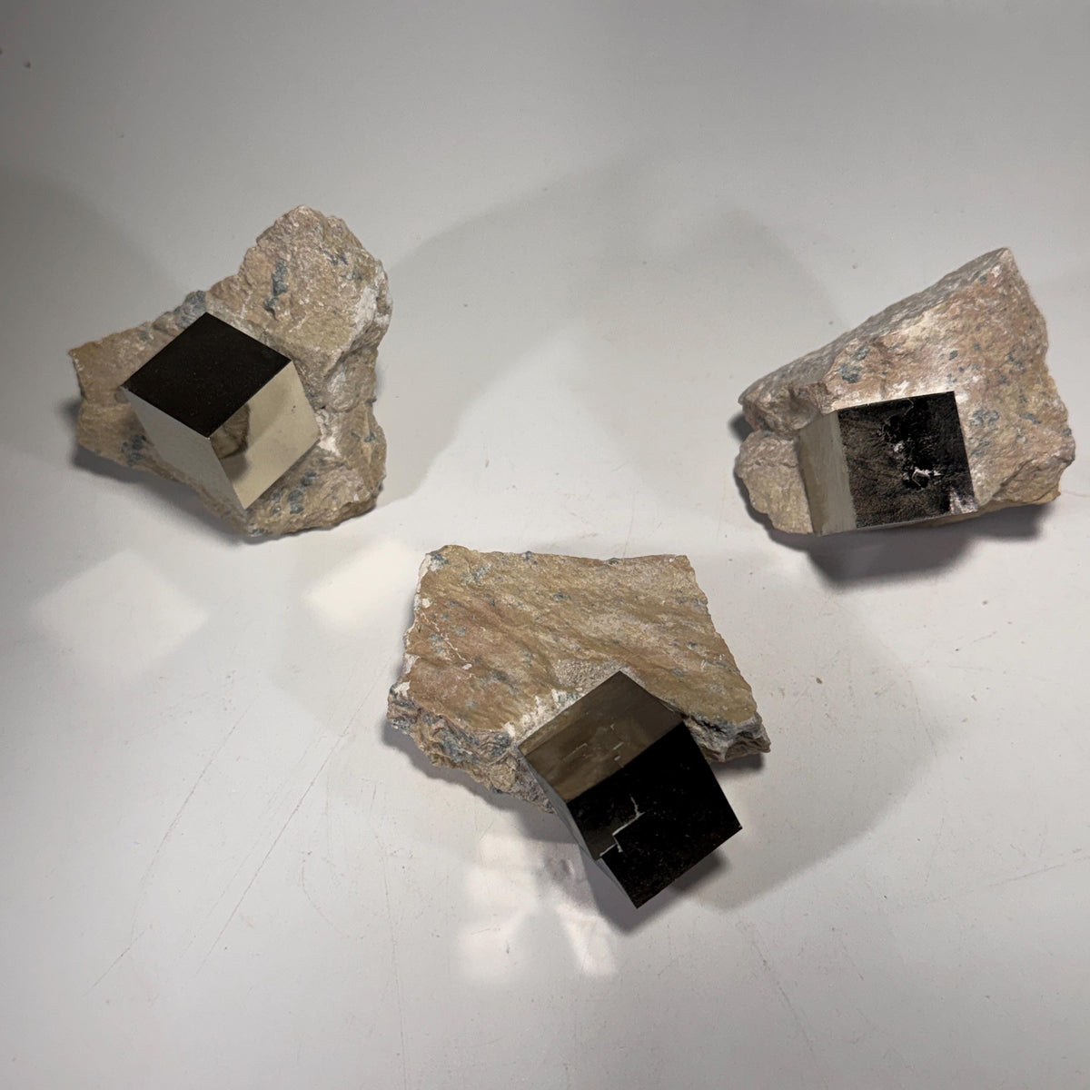 Pyrite crystal in matrix cluster with dark cube openings in rock