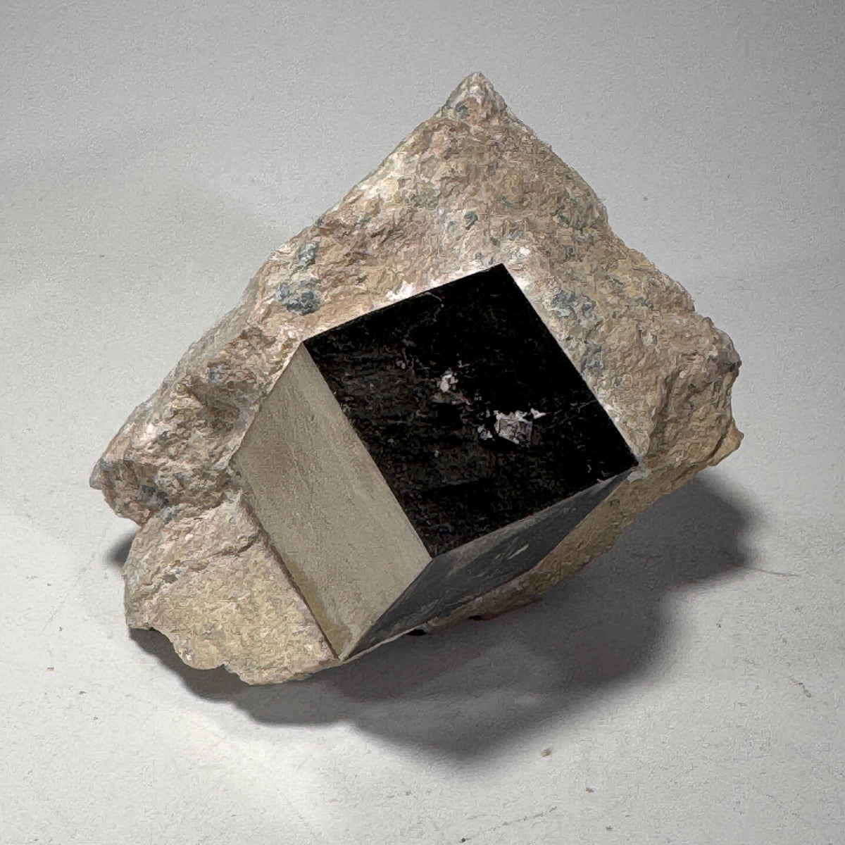 Pyrite crystal in matrix with a dark, blocky cube core